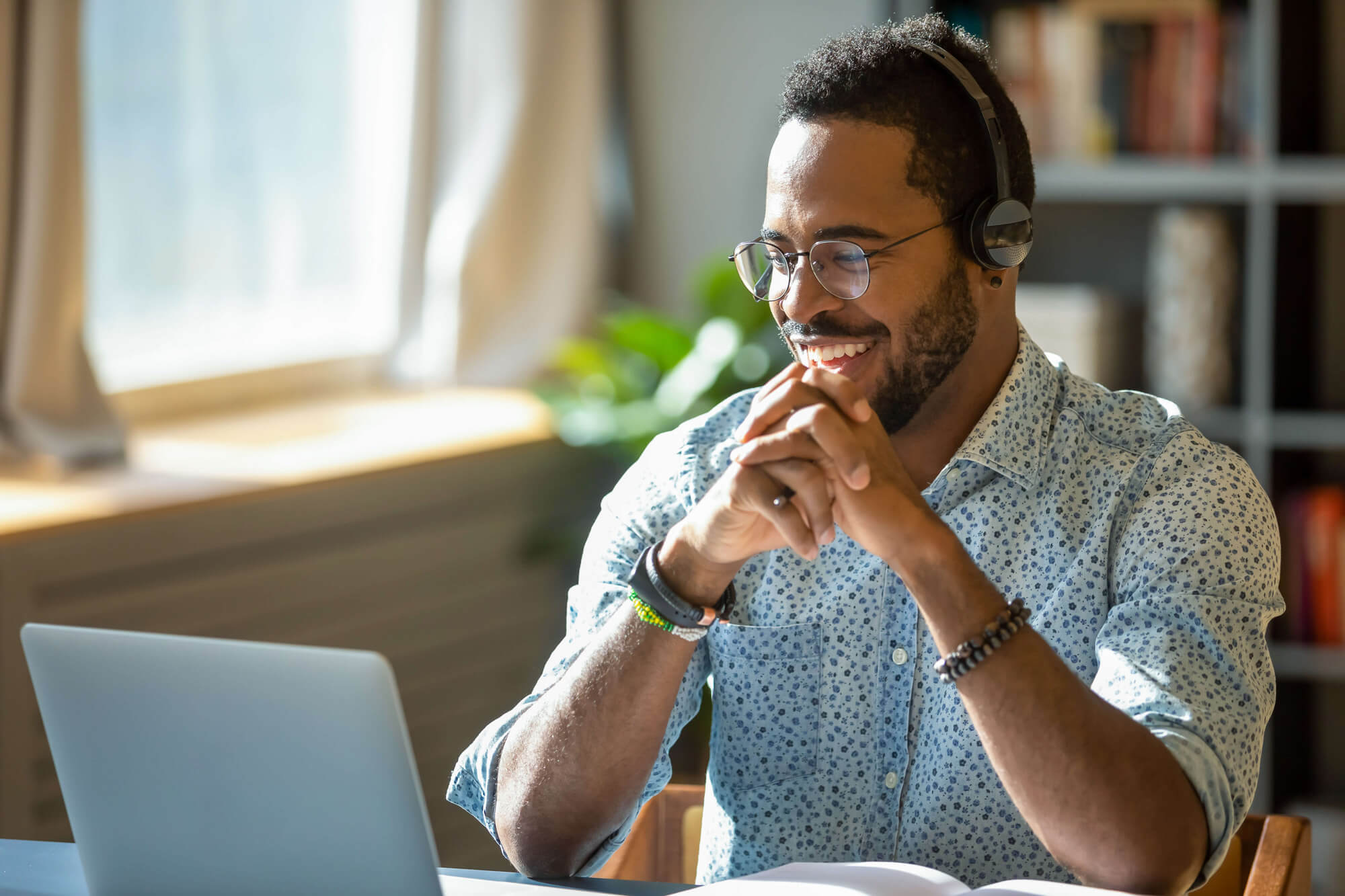 Man wearing headphones looking at a laptop.